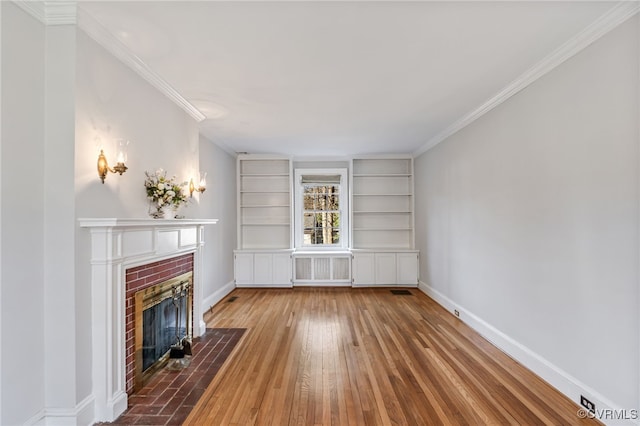 unfurnished living room featuring crown molding, a fireplace, baseboards, and hardwood / wood-style floors