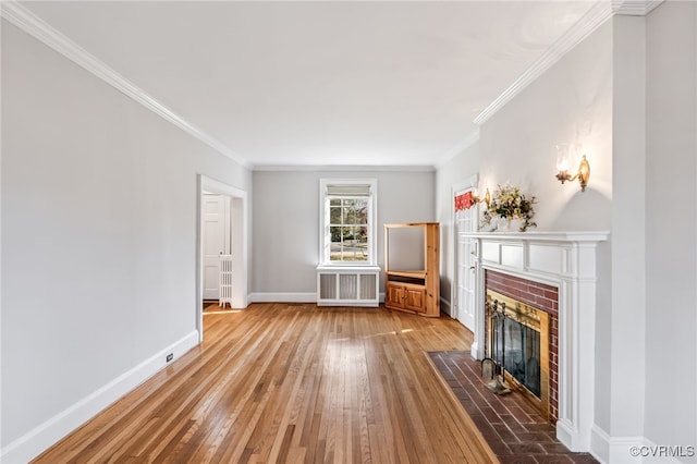 unfurnished living room featuring baseboards, radiator heating unit, ornamental molding, hardwood / wood-style floors, and a fireplace