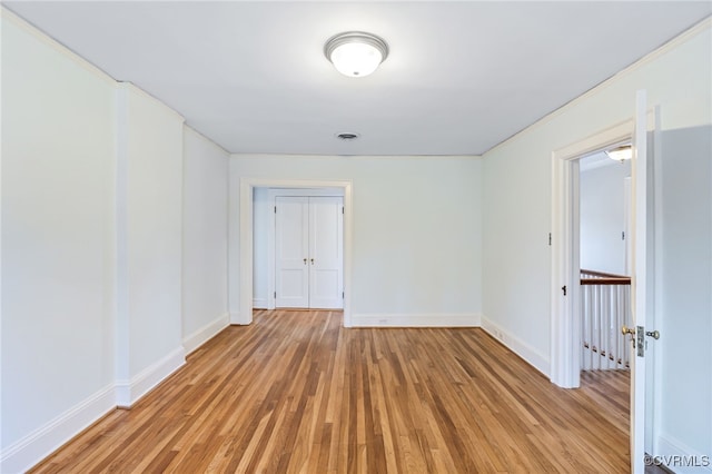 unfurnished room with baseboards, visible vents, and light wood finished floors