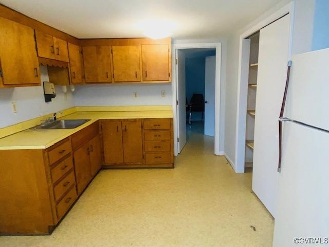 kitchen featuring white refrigerator and sink