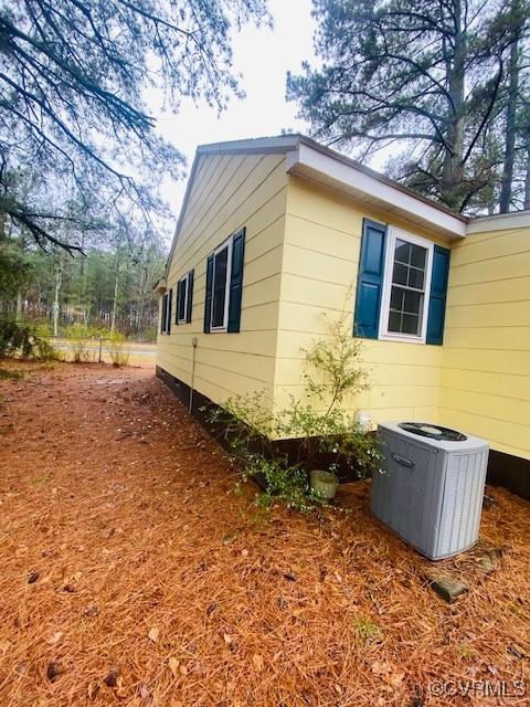 view of side of home with central air condition unit