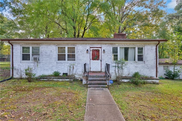 view of front facade featuring a front yard and cooling unit