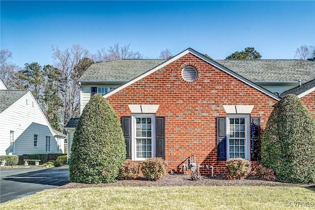 traditional-style house with brick siding and a shingled roof