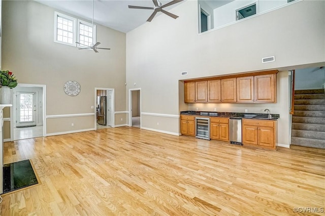 kitchen with wine cooler, visible vents, light wood-style floors, a ceiling fan, and dark countertops