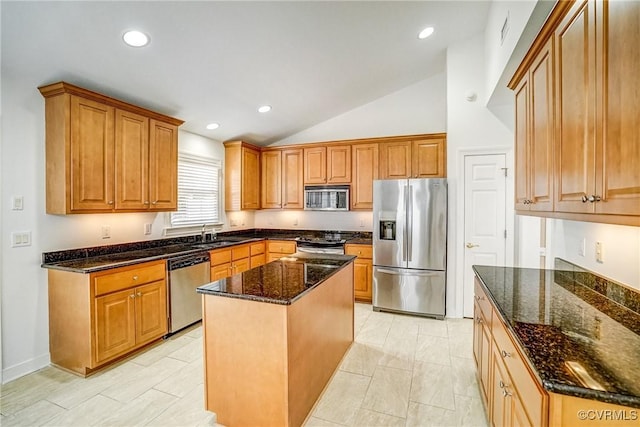 kitchen with appliances with stainless steel finishes, dark stone counters, and brown cabinetry