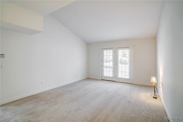 carpeted spare room with lofted ceiling and baseboards