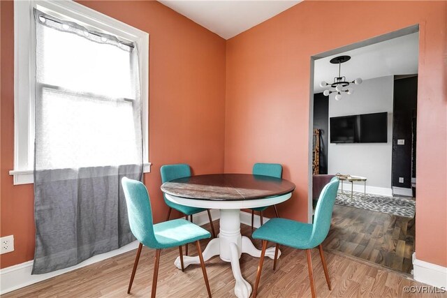 dining area with an inviting chandelier and light wood-type flooring