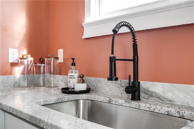 room details featuring light stone counters and indoor wet bar