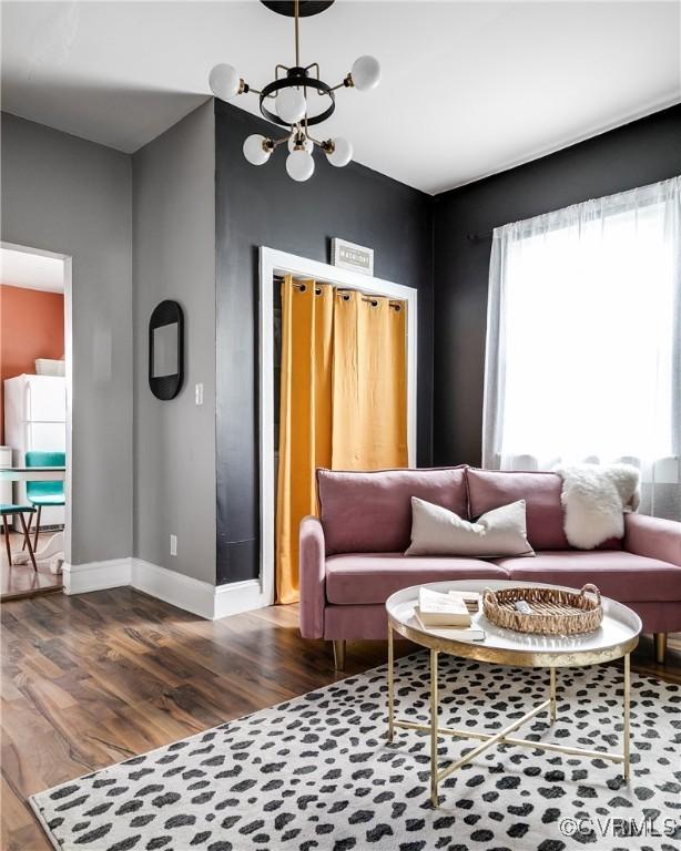 living room with dark wood-type flooring and a chandelier