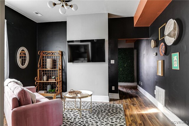 living room featuring an inviting chandelier and wood-type flooring