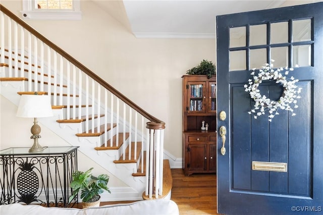 entrance foyer with stairs, baseboards, wood finished floors, and crown molding