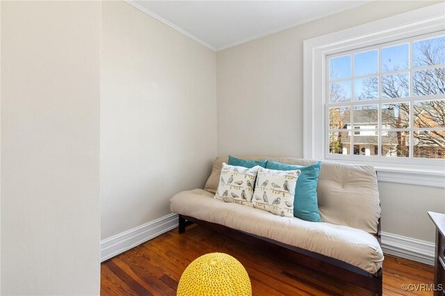 living area with ornamental molding, baseboards, and wood finished floors