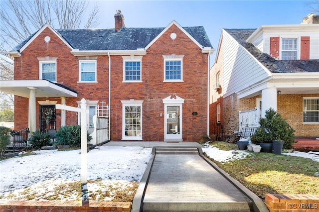 view of front of home featuring brick siding and a chimney