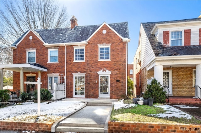 view of front of property with brick siding and a chimney