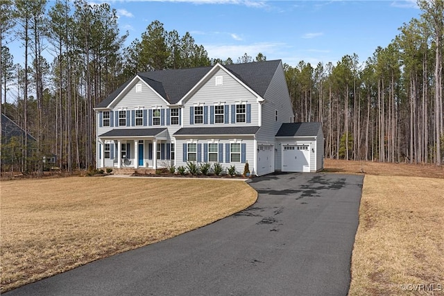 view of front of house with driveway, a porch, and a front yard