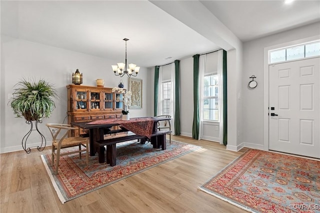 dining room featuring plenty of natural light, an inviting chandelier, and light wood-type flooring