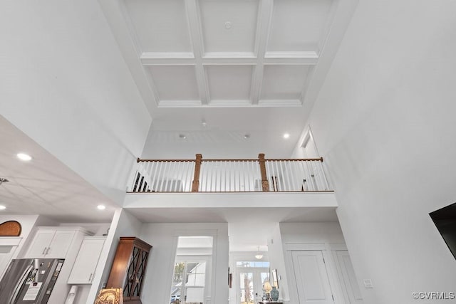 interior space with white cabinets, coffered ceiling, stainless steel fridge with ice dispenser, beamed ceiling, and recessed lighting