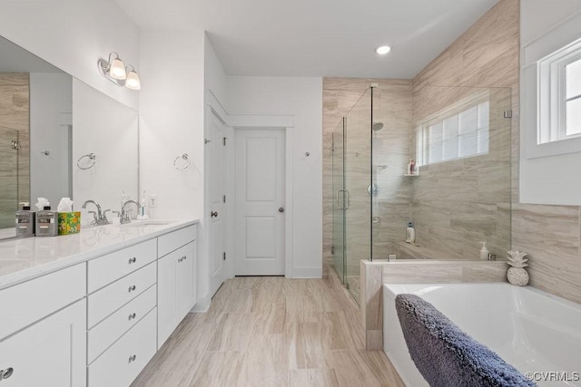 full bathroom featuring double vanity, a stall shower, a garden tub, and a sink