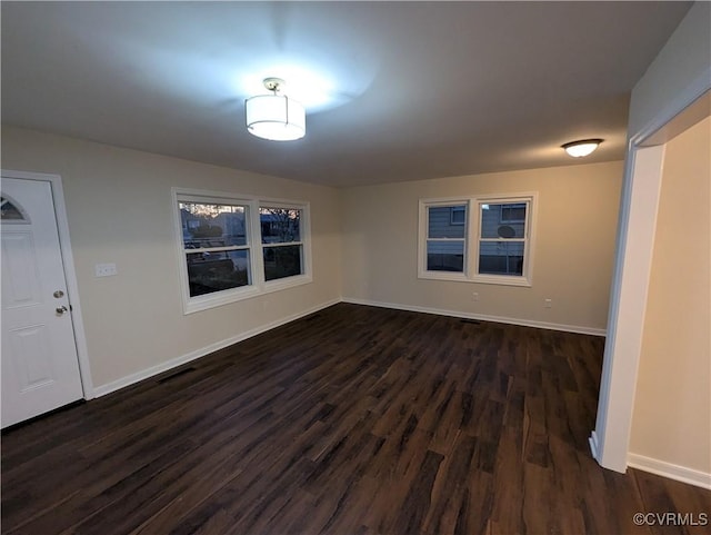 empty room with dark hardwood / wood-style flooring