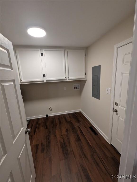 washroom with washer hookup, dark hardwood / wood-style flooring, electric panel, and cabinets