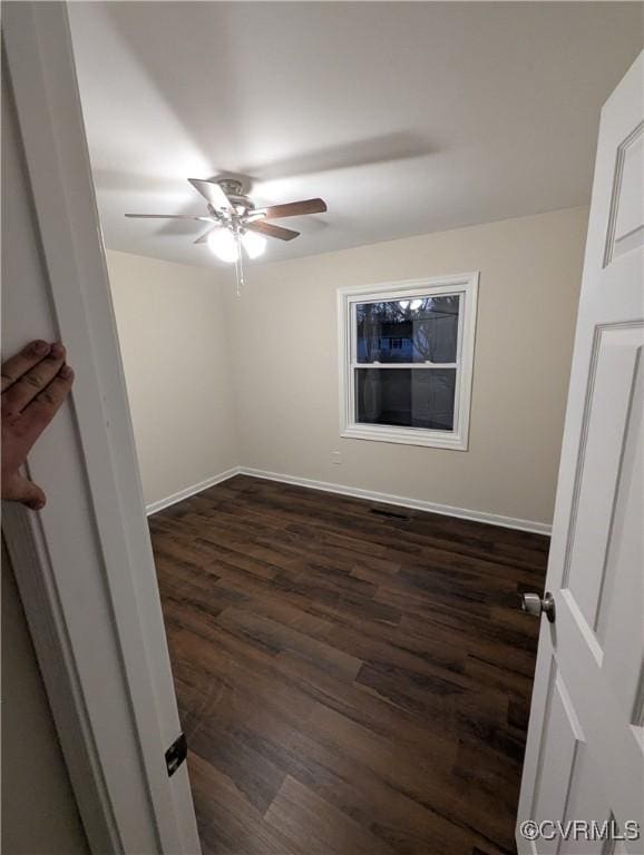 spare room featuring ceiling fan and dark hardwood / wood-style floors