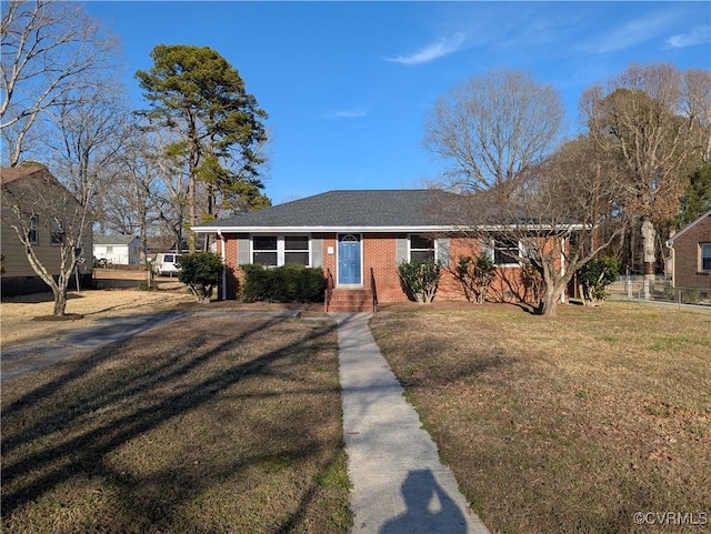 ranch-style house with roof with shingles, fence, a front lawn, and brick siding