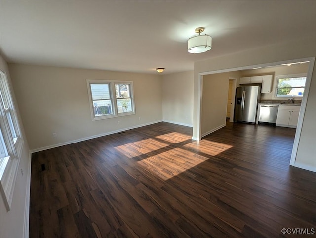 interior space with dark wood-style floors, a sink, and baseboards