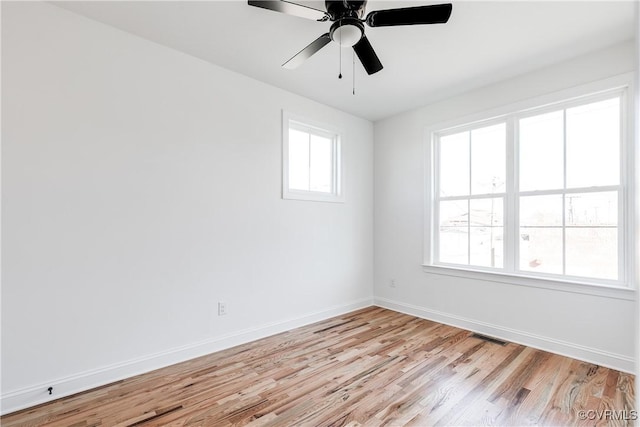 spare room with plenty of natural light, ceiling fan, and light hardwood / wood-style flooring