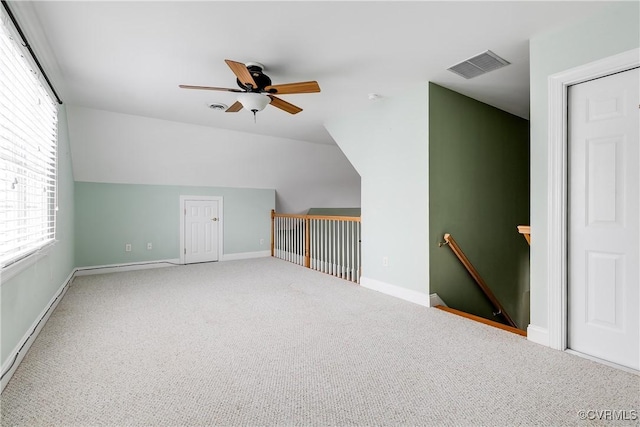 additional living space featuring a baseboard radiator, visible vents, vaulted ceiling, and carpet flooring