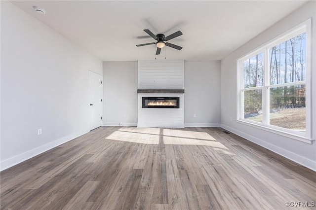 unfurnished living room featuring ceiling fan, a fireplace, and hardwood / wood-style floors