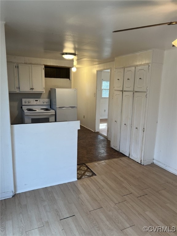 kitchen with light wood-type flooring, white cabinets, and white appliances