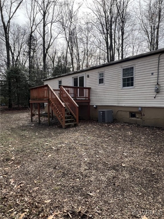 back of property featuring central AC unit and a deck