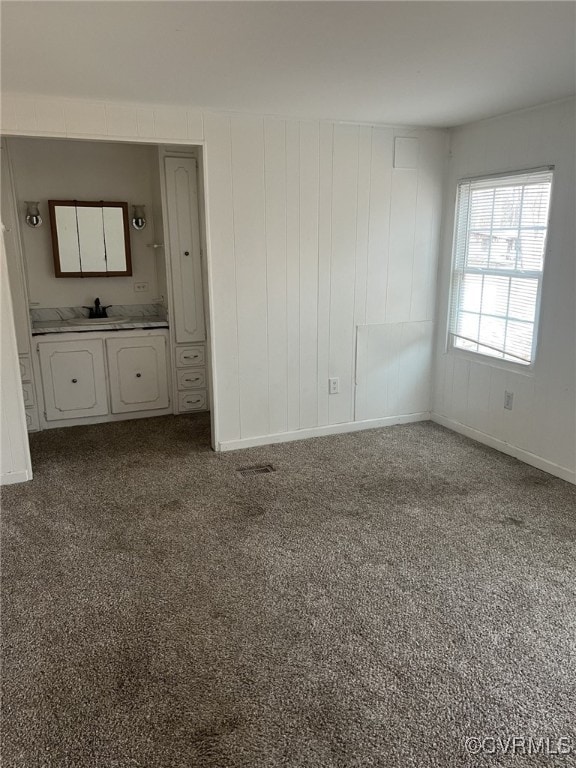 unfurnished room featuring carpet floors and sink