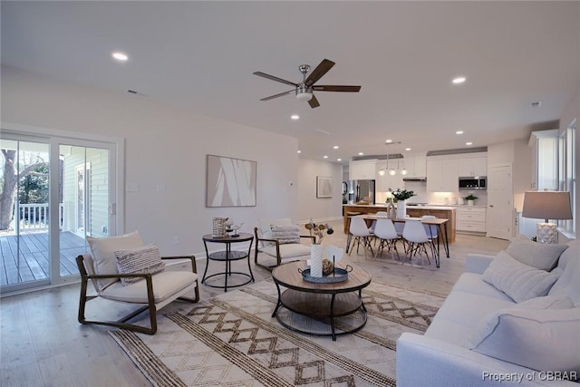 living room with ceiling fan and light hardwood / wood-style flooring