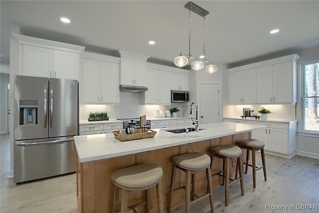 kitchen featuring a center island with sink, white cabinets, and appliances with stainless steel finishes