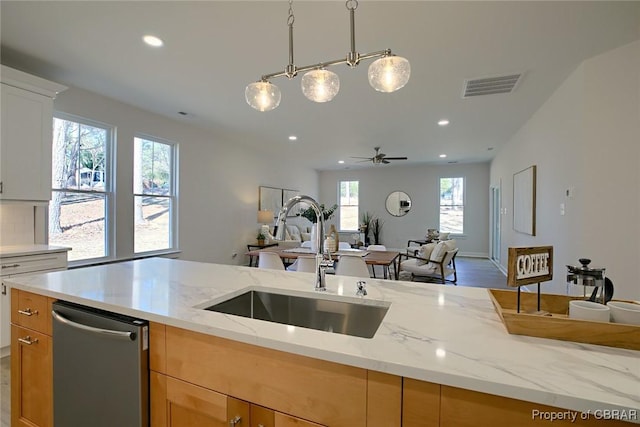 kitchen featuring sink, stainless steel dishwasher, white cabinets, and light stone counters