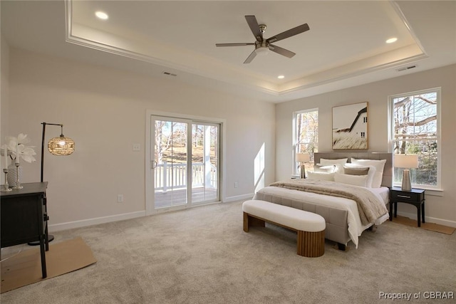 carpeted bedroom featuring a raised ceiling, ceiling fan, access to exterior, and multiple windows