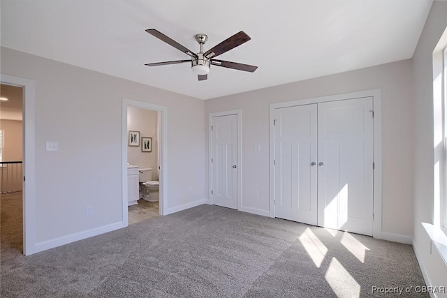 unfurnished bedroom featuring ensuite bath, light colored carpet, and ceiling fan