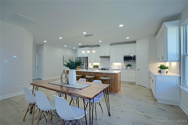 dining room with sink and light hardwood / wood-style flooring