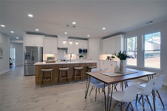 dining area featuring sink and light wood-type flooring