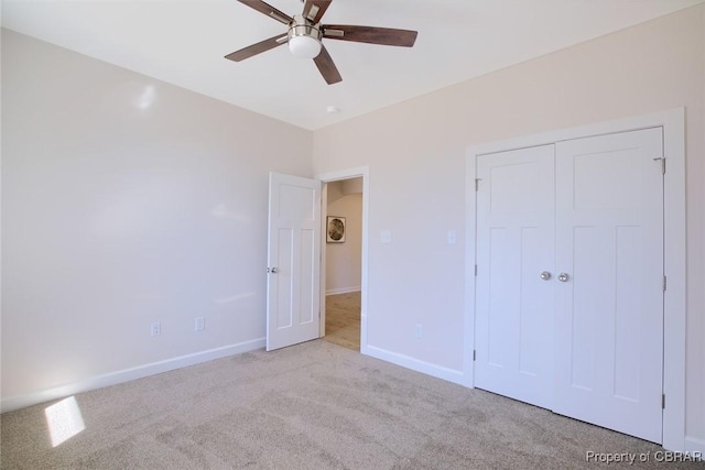 unfurnished bedroom featuring light colored carpet, ceiling fan, and a closet