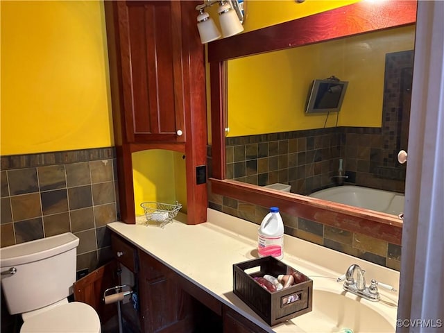 bathroom with toilet, sink, tile walls, and a bath