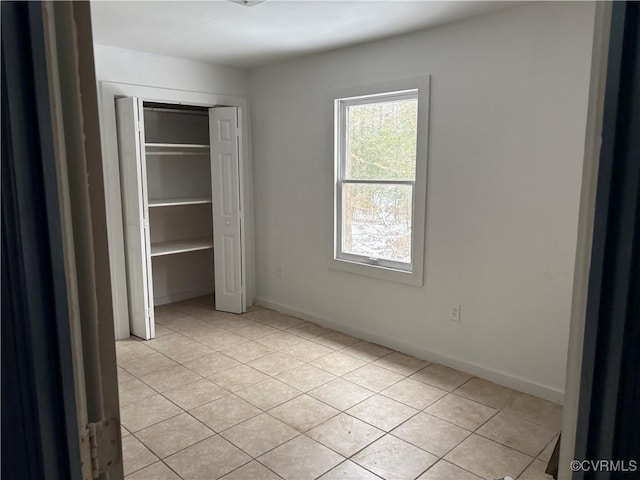 unfurnished bedroom featuring light tile patterned floors and a closet