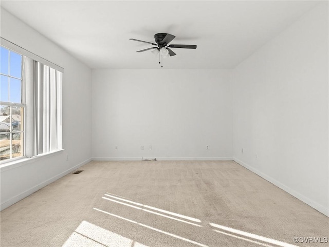 unfurnished room with ceiling fan, plenty of natural light, and light carpet