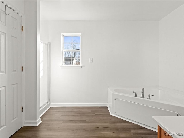 bathroom with hardwood / wood-style flooring, vanity, and a washtub