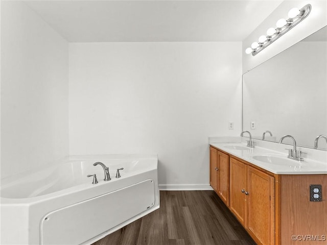 bathroom featuring vanity, wood-type flooring, and a bathtub