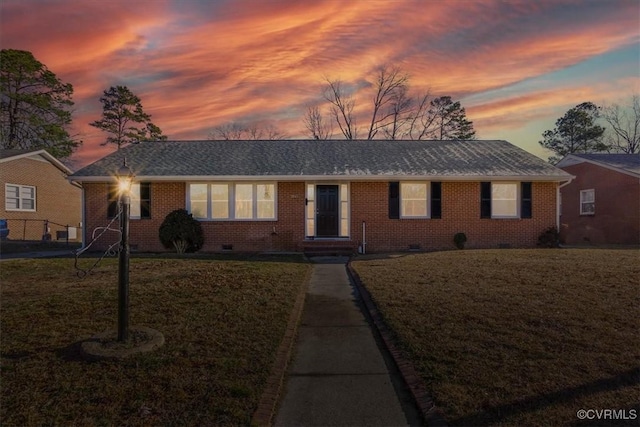 ranch-style home with a yard