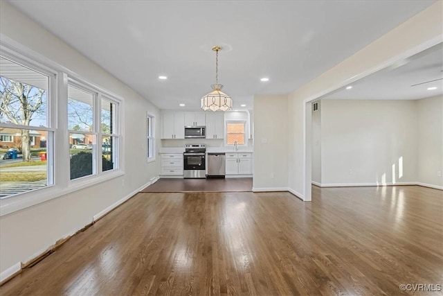 unfurnished living room with dark hardwood / wood-style flooring and sink