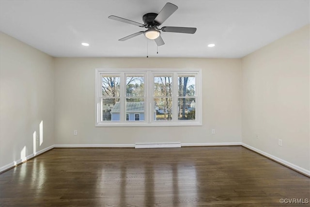 spare room featuring dark hardwood / wood-style flooring, ceiling fan, and baseboard heating