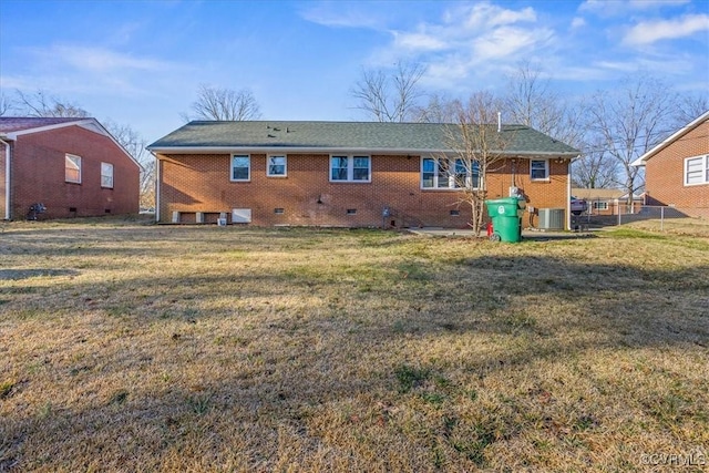 rear view of house featuring central AC unit and a yard